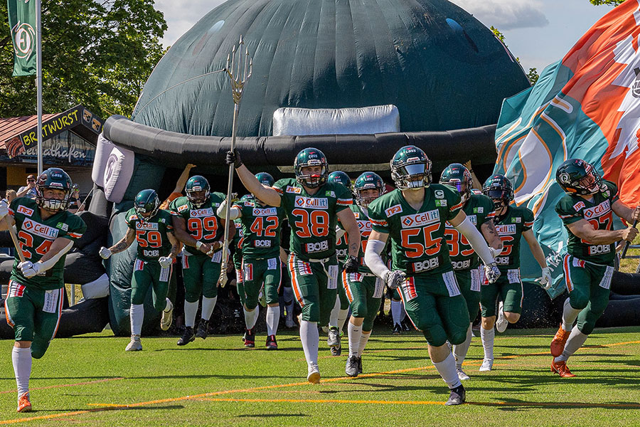 Das Foto zeigt das Team der Kiel Baltic Hurricanes in ihren dunkelgrünen Heim-Jerseys beim Einlauf in das Kilia Stadion.